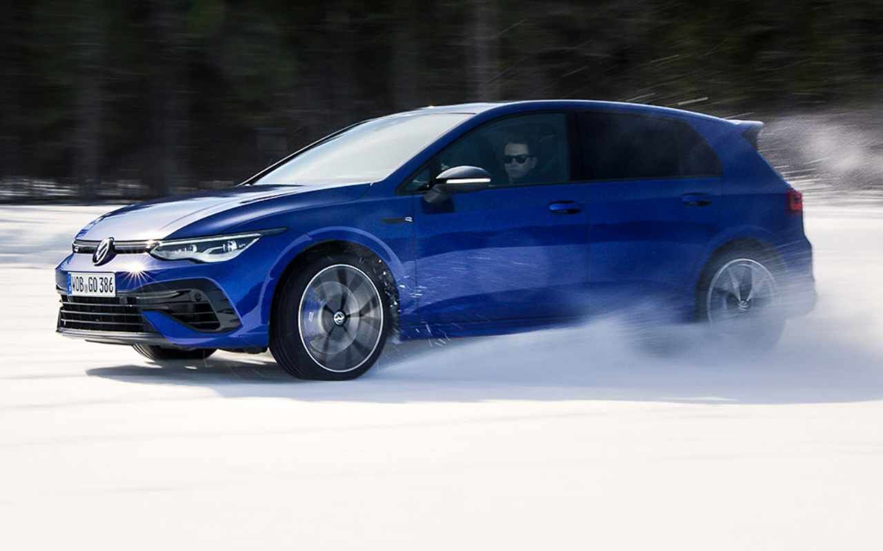 side view of a 2022 VW Golf R driving on snow