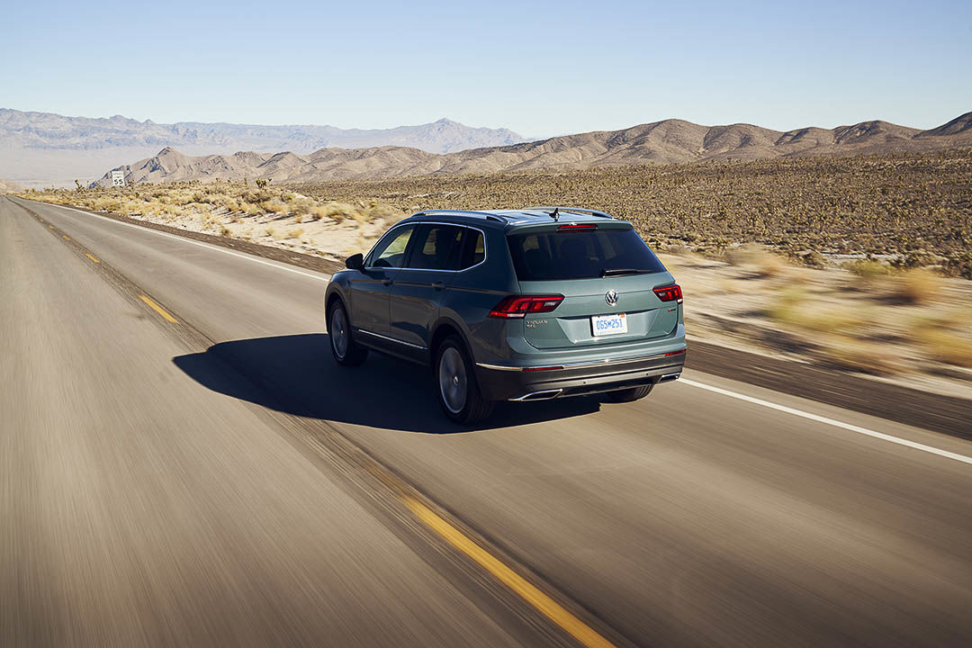three quarter rear view of the 2021 Volkswagen Tiguan driving down a road