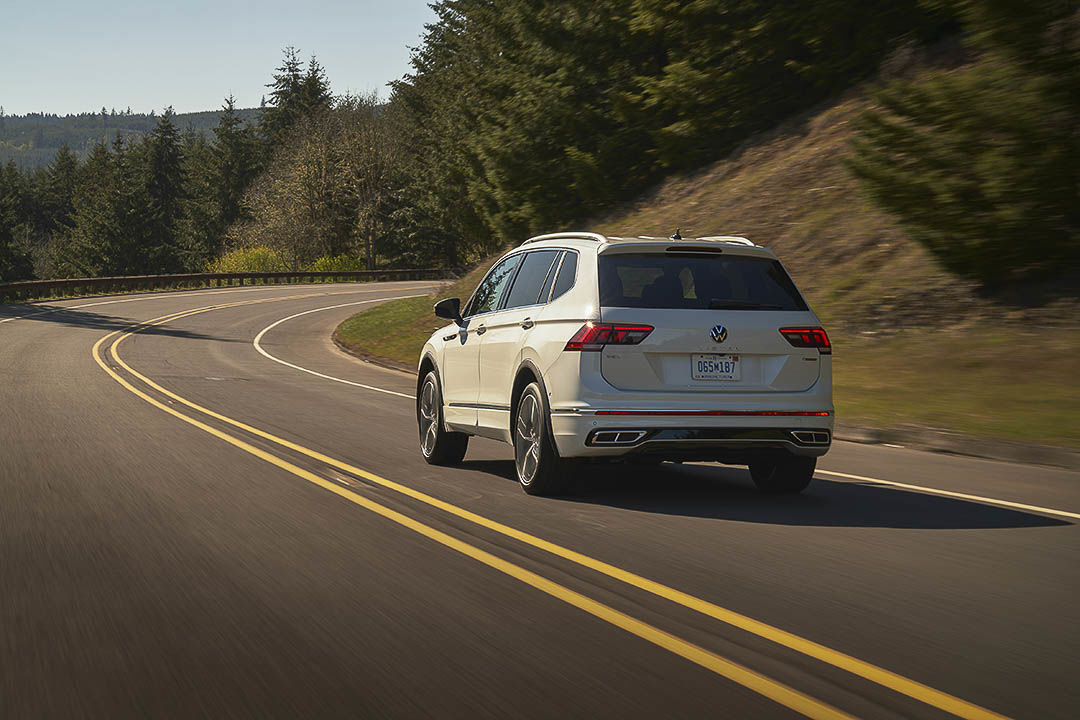 Left side and back of a white 2022 Volkswagen Tiguan rolling on the road