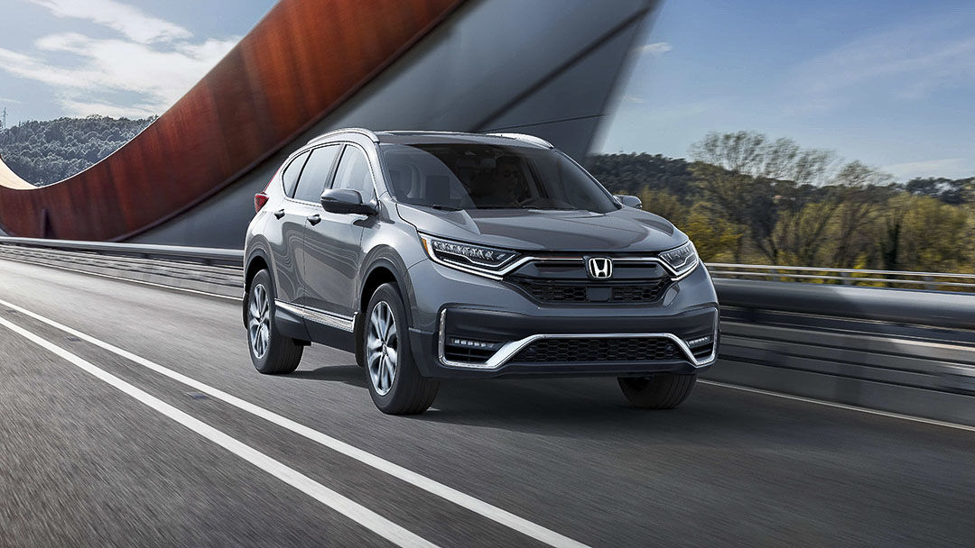 three quarter front view of the 2021 Honda CR-V driven on a road