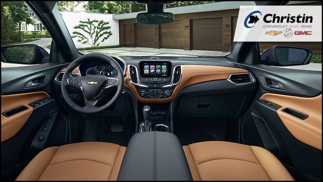 Image de l'intérieur du SUV compact Chevrolet Equinox 2018 qui montre les sièges en cuir couleur brun clair, le volant, l'écran de bord et d'autres caractéristiques de la voiture