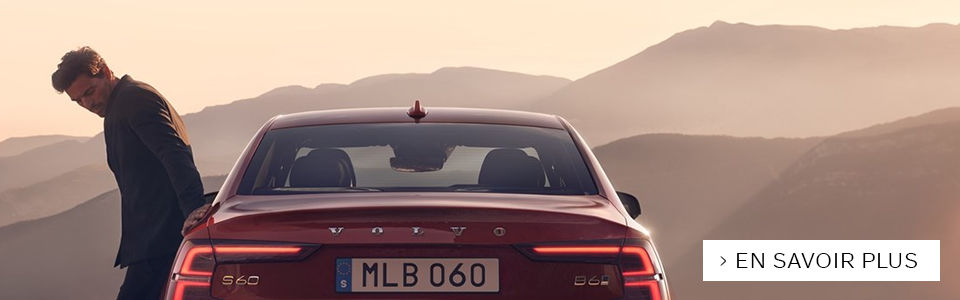 Image d'un volvo s60 rouge vu de derrière avec un homme sur le côté de la voiture 