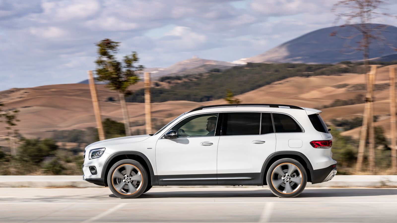 2026 Mercedes-Benz GLB - Side profile view of a white 2026 Mercedes-Benz GLB in motion - Mercedes-Benz Brampton - New car dealership in Brampton, Ontario