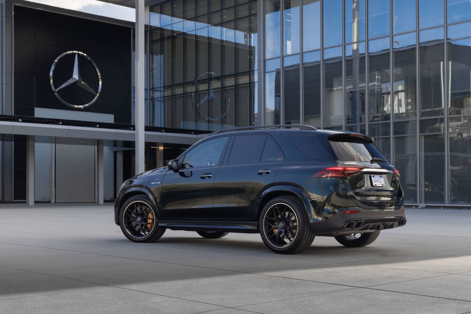 2026 Mercedes-Benz GLE 63 S AMG - Rear three-quarter view of a black 2026 Mercedes-Benz GLE 63 S AMG parked in front of a modern glass building - Mercedes-Benz Brampton - New car dealership in Brampton, Ontario