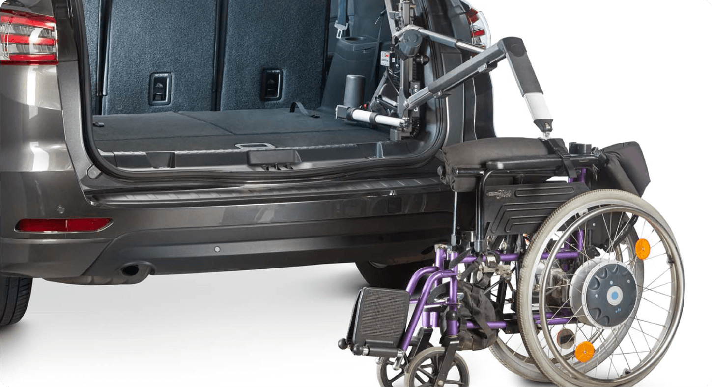 Open trunk view of an SUV with an interior hoist lifting a wheelchair into the cargo area - Humberview Mobility - Accessible car dealership in Toronto, Ontario