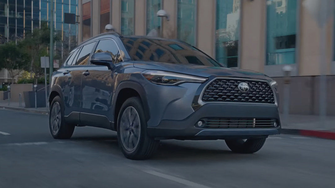 vue latérale avant d'une Toyota Corolla Cross 2024 sur un boulevard en ville