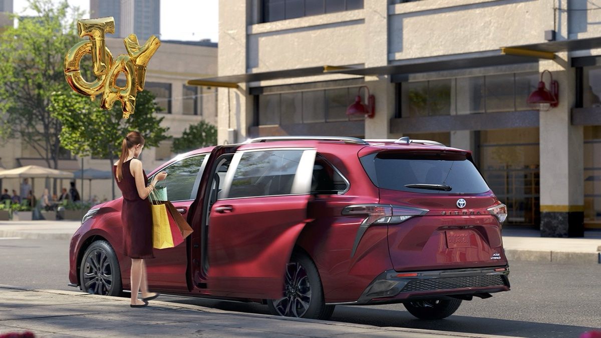 vue latérale arrière d'une femme qui s'apprête à monter à bord d'une Toyota Sienna 2024 avec un bouquet de ballons en forme de lettres