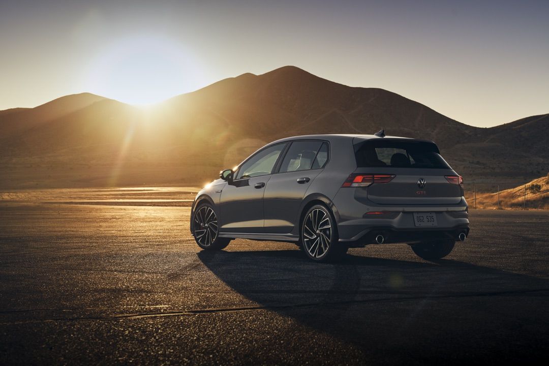 Rear 3/4 view of the 2022 Volkswagen Golf GTI parked facing the mountains