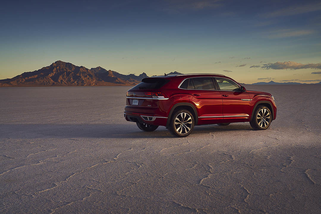 Side 3/4 view of 2021 VW Atlas Cross Sport chrome aurora red parked on desert land