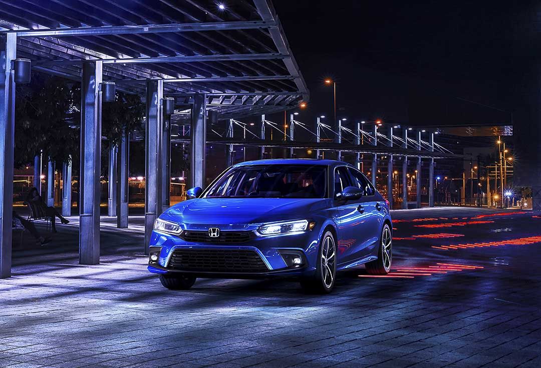 La Honda Civic Touring 2022 Bleu Égéen métallisé garée à l'extérieur pendant la nuit
