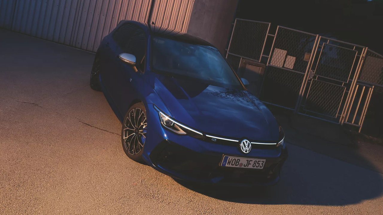 Vue 3/4 avant et latérale de la Golf R 2025 dans un stationnement a l'extérieur la nuit avec les phares allumés