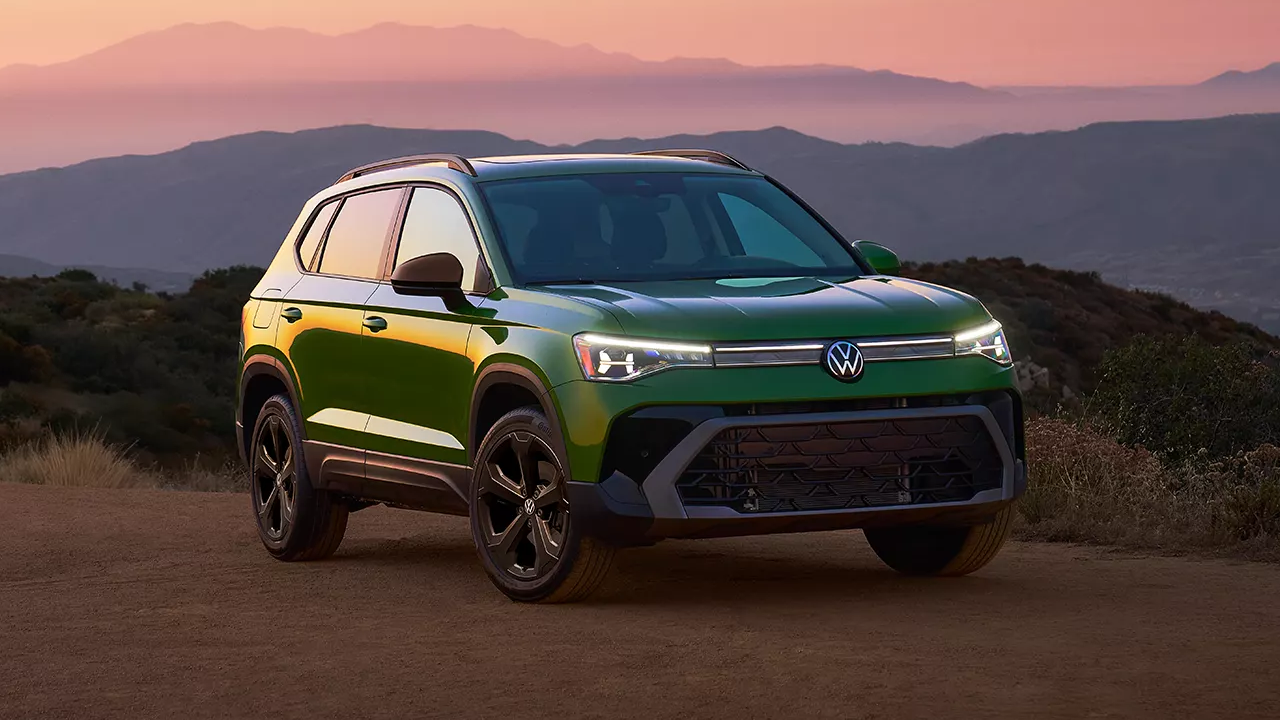 3/4 front and side view of the Volkswagen Taos 2025 stopped on a sandy roadside with a sunset.