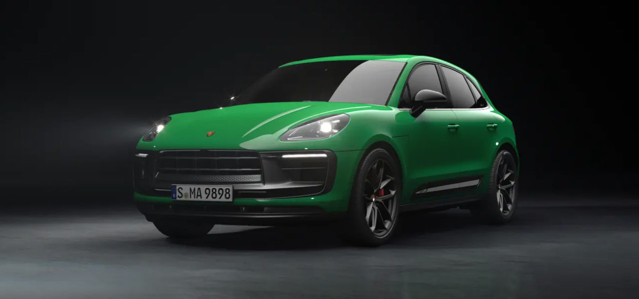 Vue 3/4 avant et latérale de la Porsche Macan 2024 sortant d'un garage avec phares allumées