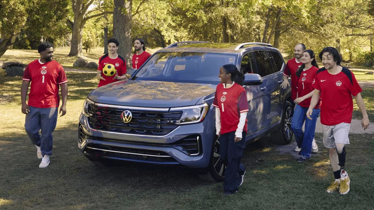 Vue 3/4 avant et lat&eacute;rale de la Volkswagen Atlas 2025 Highline&nbsp;4MOTION 7 places d&eacute;barquant une &eacute;quipe de soccer