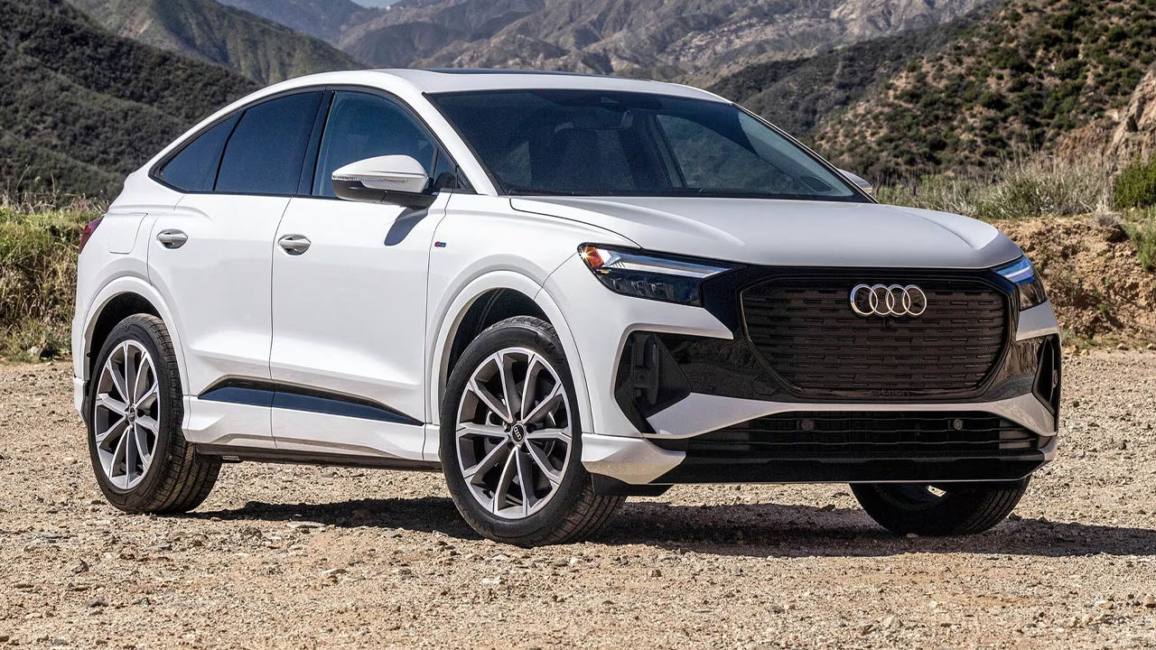 Front view of the Audi Q4 Sportback e-tron 2024 on a sandy road on a summer's day