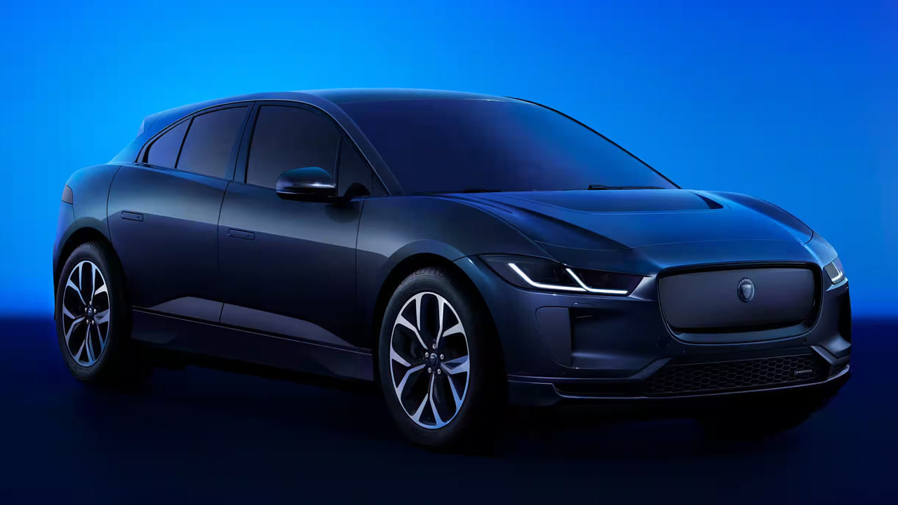 Side view of Jaguar I-Pace in showroom with headlights on