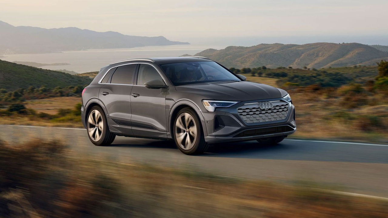 Side view of Audi Q8 e-tron in road power with seascape