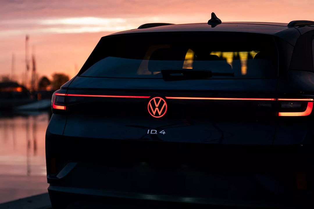 Vue arrière de la Volkswagen ID.4 2024 avec phares allumées et coucher de soleil