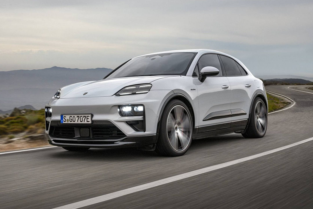 Vue 3/4 avant et latérale de la Porsche Macan EV 2024 sur route en pleine puissance