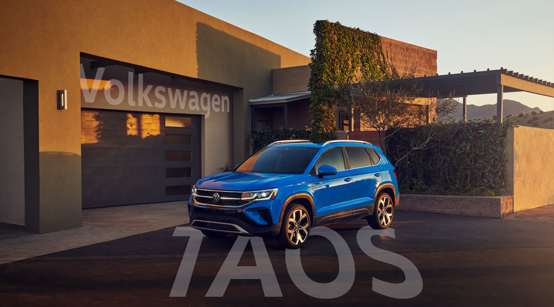 three quarter front view of the 2022 Volkswagen Taos parked in front of a house