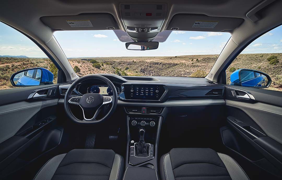 view of the living space inside of the 2022 Volkswagen Taos with the steering wheel, dashboard and central console