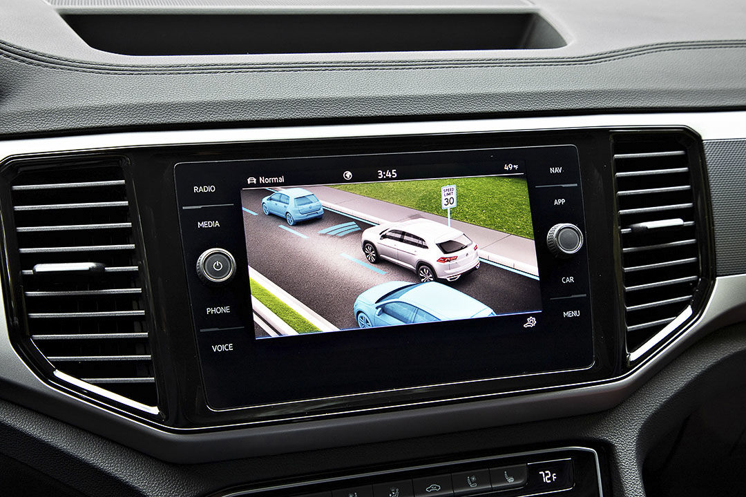view of the touchscreen and of the blind spot monitoring systeme inside of the 2022 Volkswagen Atlas Cross Sport