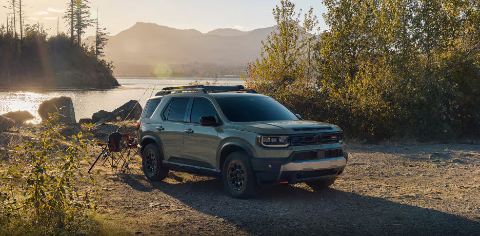 vue latérale avant d'un Honda Passport 2025 stationné sur un terrain de camping près d'un lac