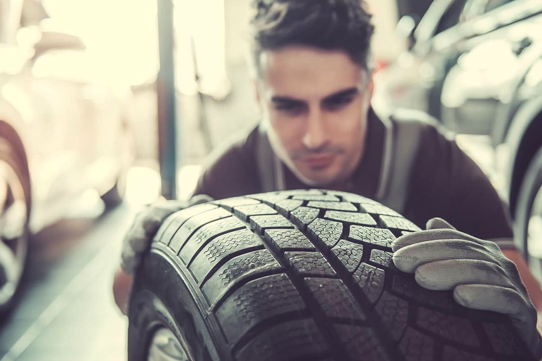 View of a Honda professional examining the quality of a Honda tire