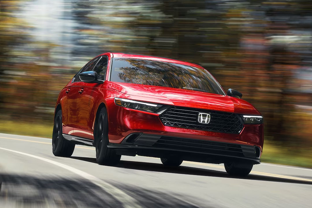 Vue du Honda Accord hybride 2024 sur route de campagne en pleine puissance
