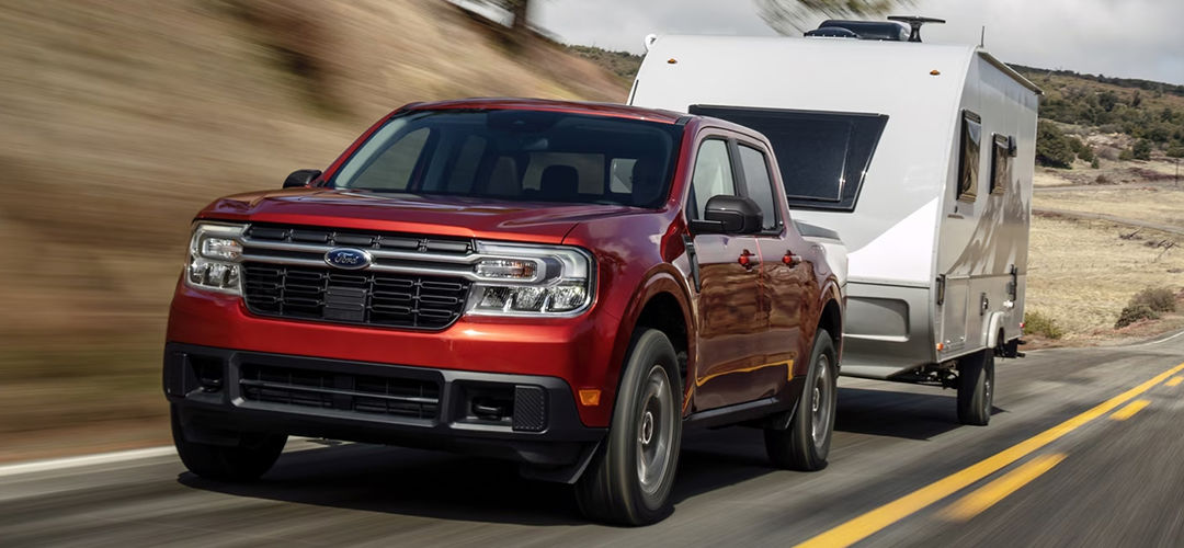 Vue 3/4 avant et latérale du Ford Maverick 2024 sur route avec roulotte