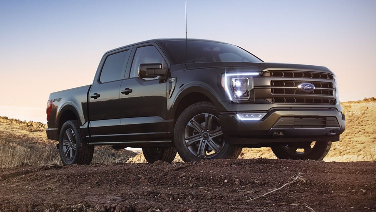 Vue 3/4 avant et lat&eacute;rale du Ford&nbsp;F-150 2022 en arr&ecirc;t sur chemin de terre