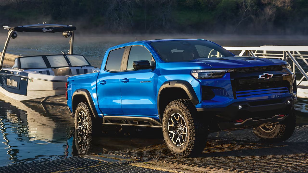 Vue 3/4 avant et lat&eacute;rale du Chevrolet Colorado 2026 remorquant un bateau sortant de l'eau