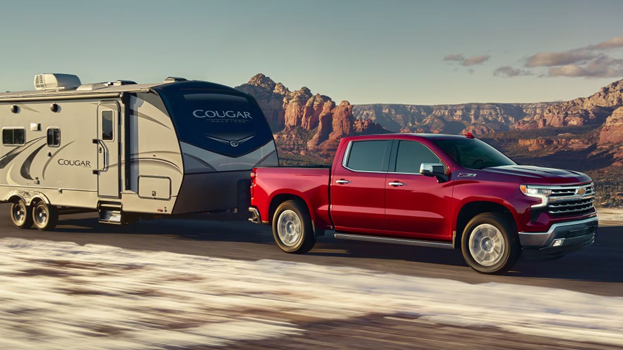 Vue 3/4 avant et lat&eacute;rale du Chevrolet Silverado&nbsp;1500 2026, tirant une remorque en pleine puissance sur route