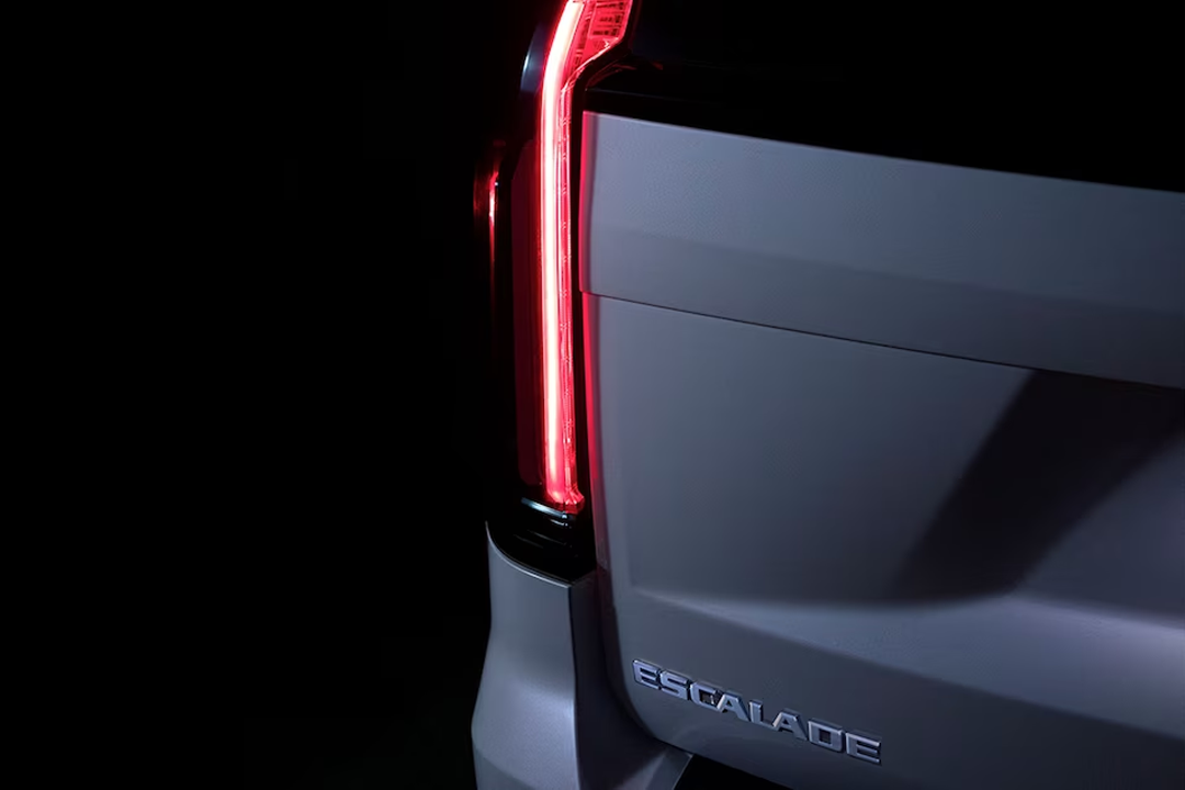 Close-up rear view of Cadillac Escalade 2024 with headlight on