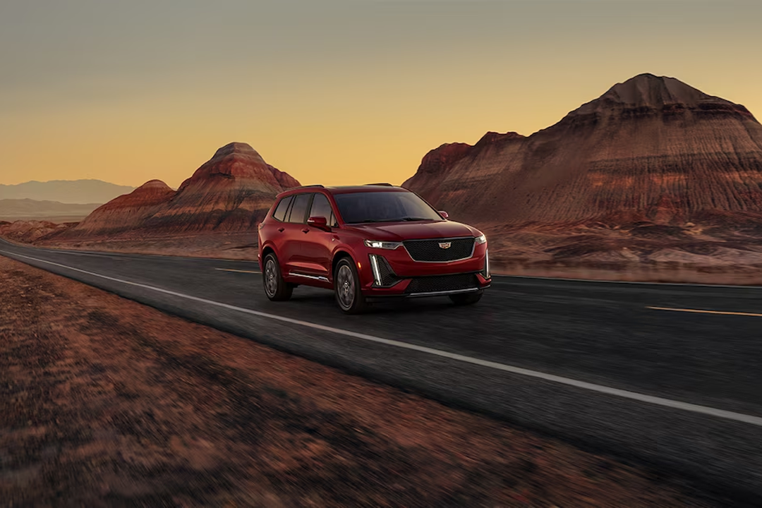 Front view of Cadillac XT6 2024 on road with sunset