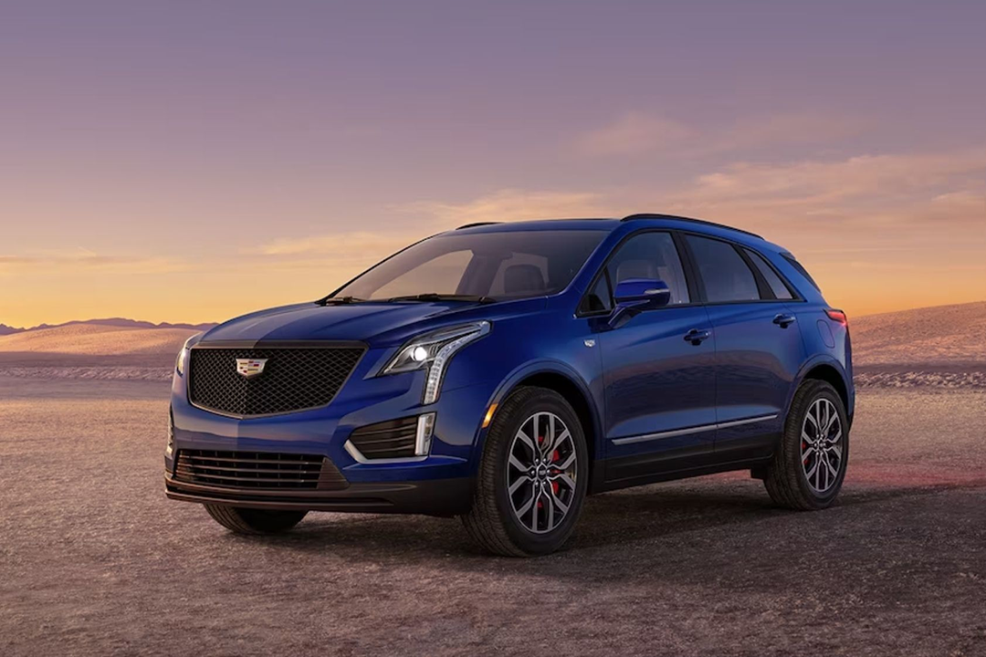 side view of Cadillac XT5 2024 on sandy road with sunrise
