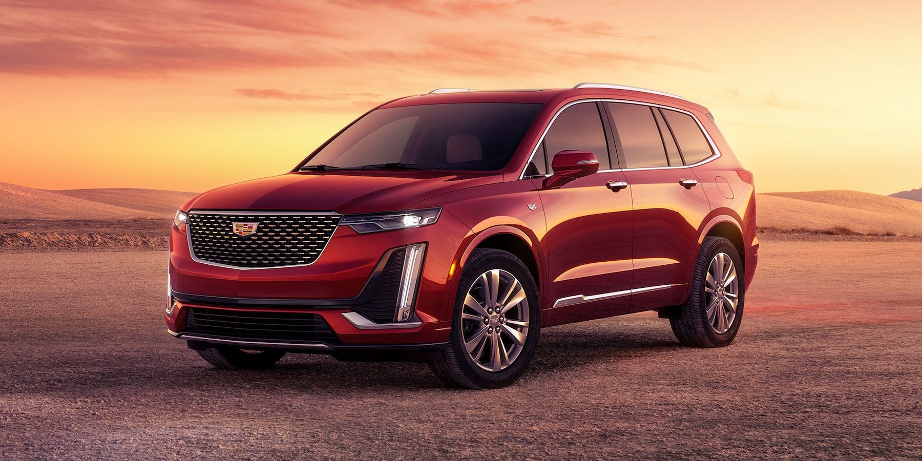 Cadillac XT6 2025 vu de face sur une plaine rocheuse pendant un lever de soleil