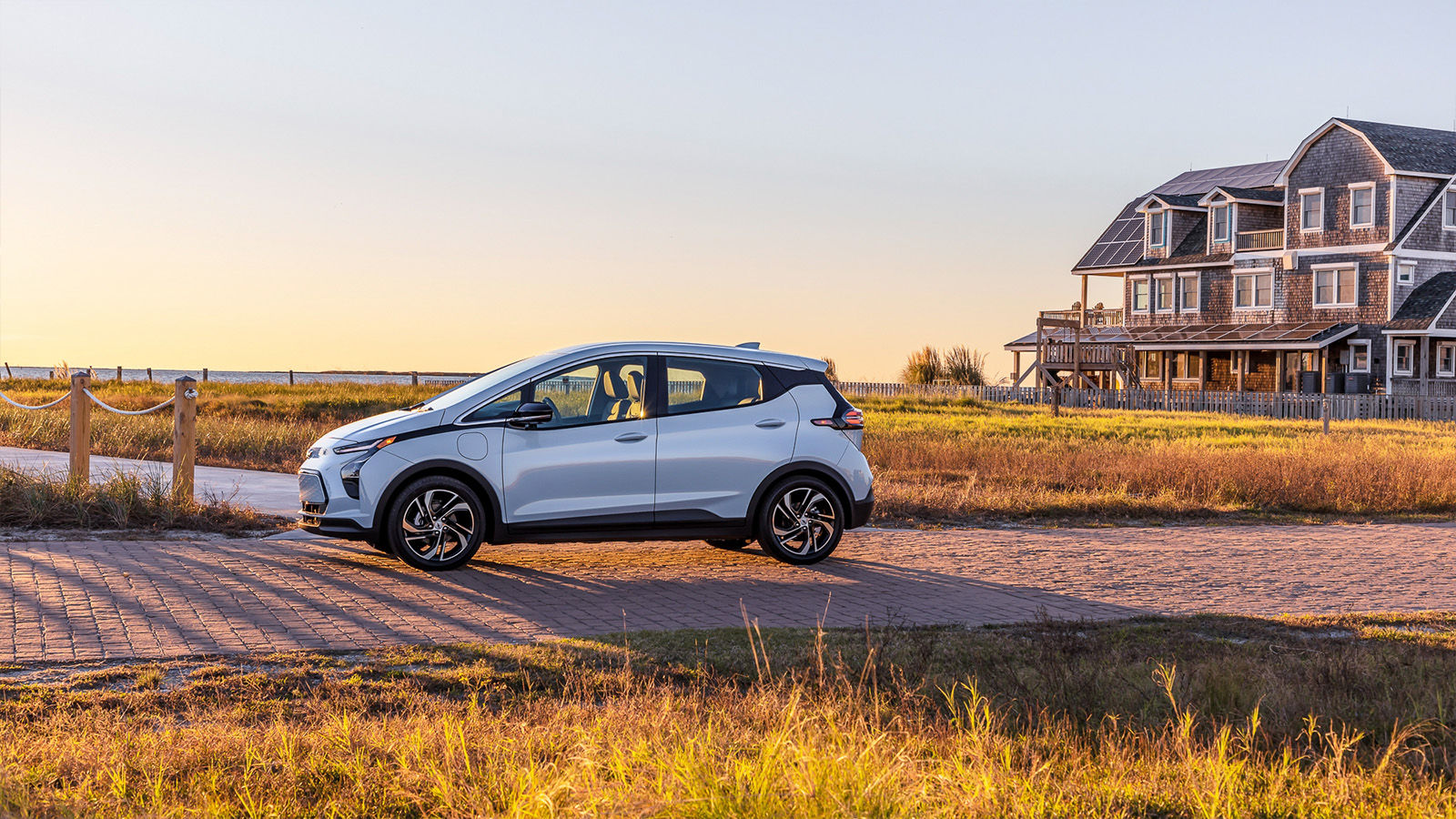 2023 chevrolet bolt ev electric white side view in a field montreal east with house