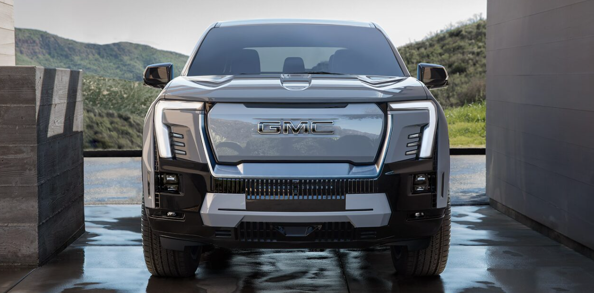 bold grille. LED headlights. distinctive light signature. aggressive front-end design. sculpted hood line. rugged style. full-width grille. modern front lighting. muscular presence. gloss black finish. electrified look. illuminated GMC emblem. enhanced aerodynamics. futuristic front fascia. balanced proportions.