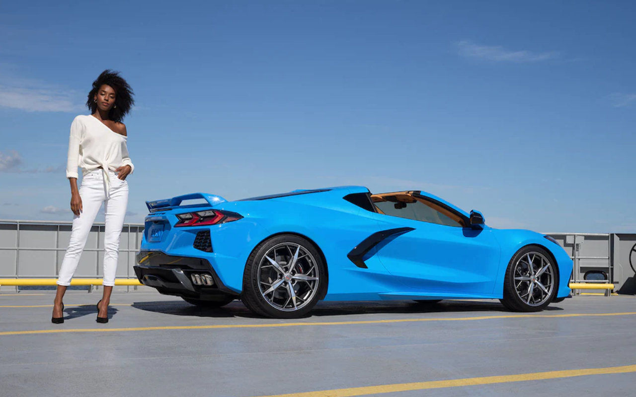 vue d'une femme debout à côté d'une Corvette Stingray 2023