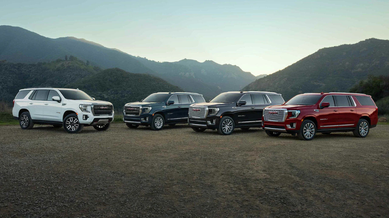 vue de 4 GMC Yukon et Yukon XL 2023 devant des montagnes