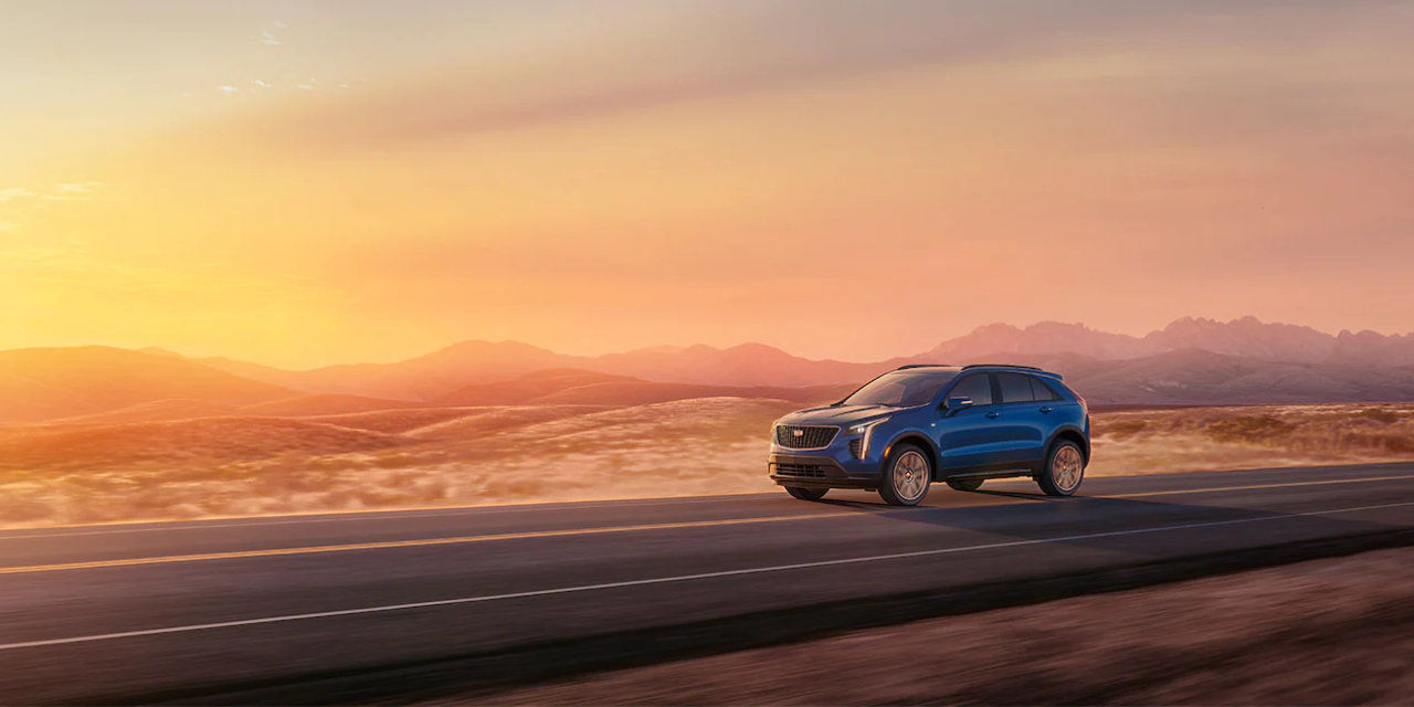 side view of a 2023 Cadillac XT4 on the road at sunset