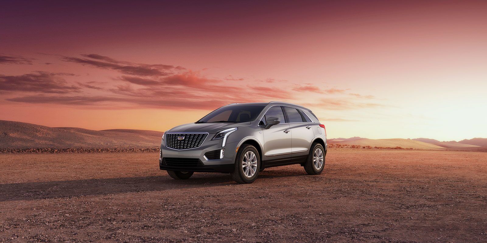 front side view of a 2023 Cadillac XT5 2023 in the desert at sunset