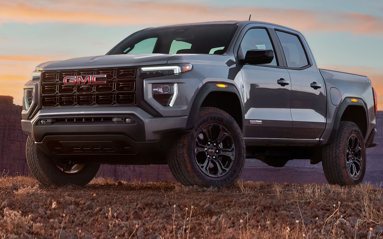 Vue 3/4 avant et latérale du GMC Canyon 2024 sur route de roche avec coucher de soleil