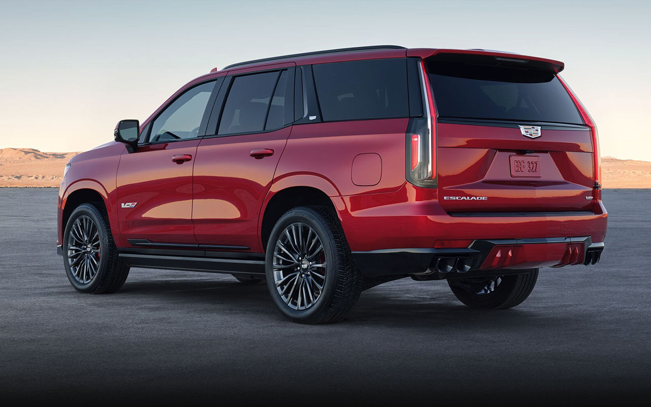 Vue arrière du Cadillac Escalade sur route de sable avec coucher de soleil