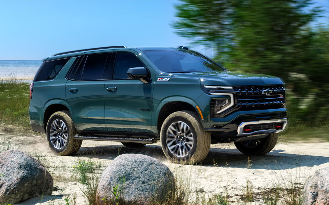 Vue 3/4 avant et latérale du Chevrolet Tahoe 2025 sur route de sable en pleine puissance