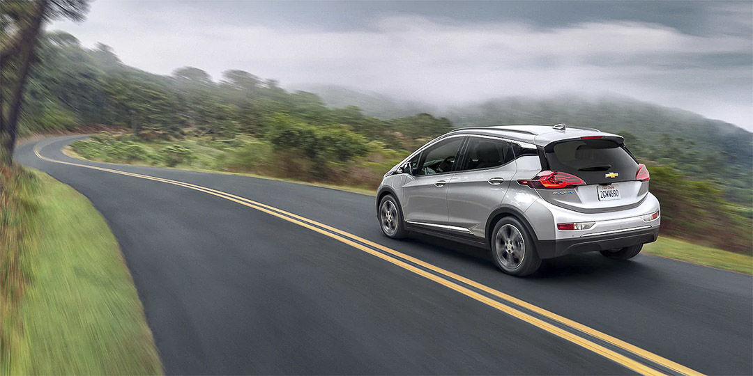 vue latérale arrière de la Chevrolet Bolt EV 2022 roulant sur une route montagneuse