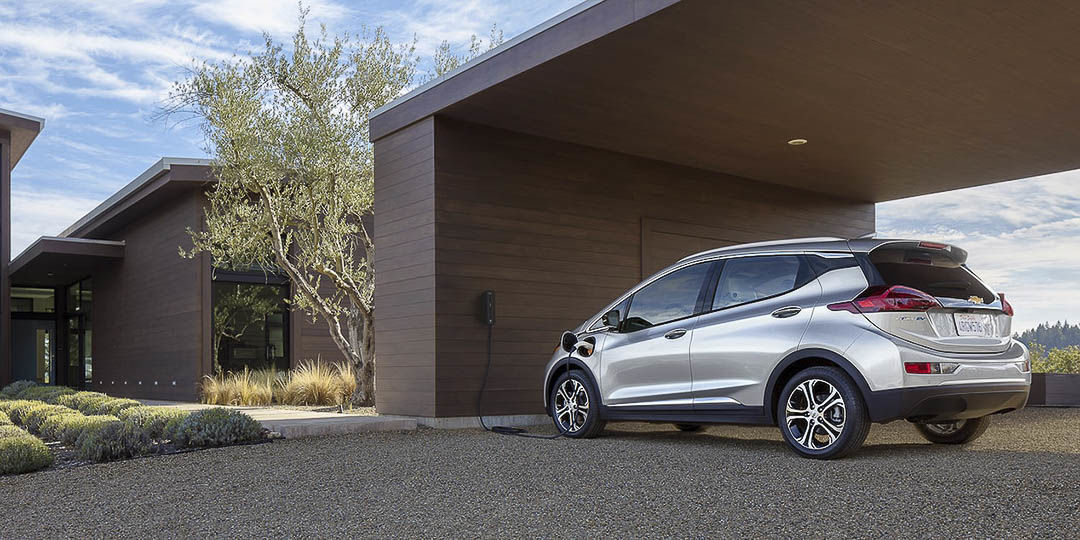 vue latéreal de la Chevrolet Bolt EV 2022 branchée à une borne de recharge