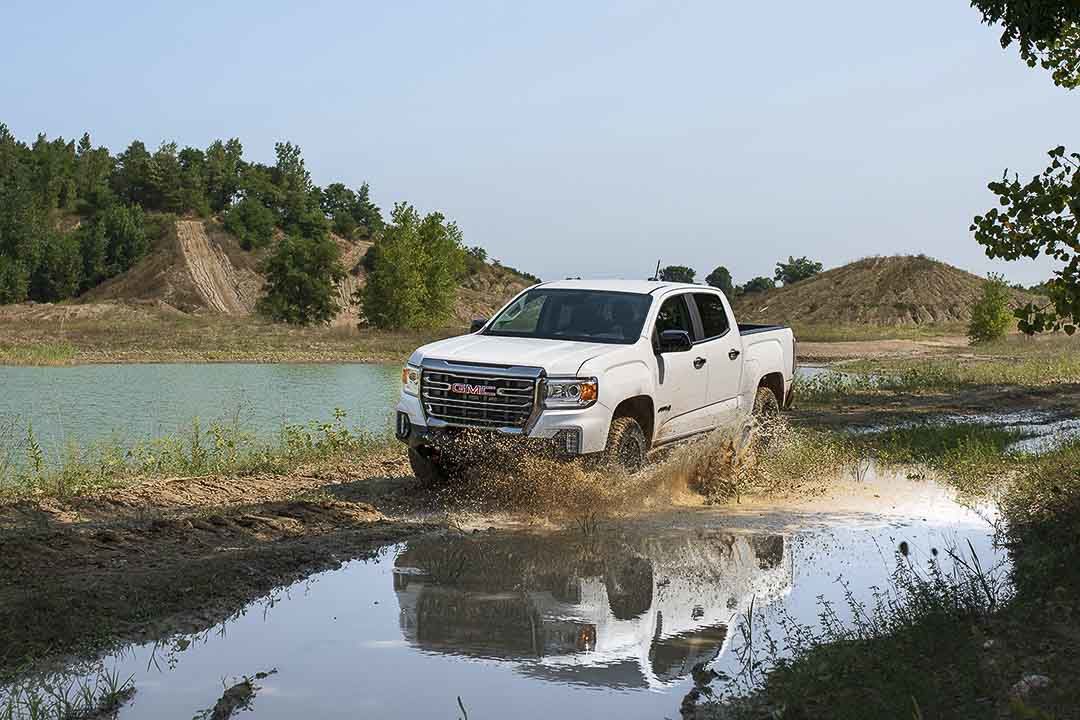 vue trois quart avant du GMC Canyion 2021 roulant sur un terrain inondé