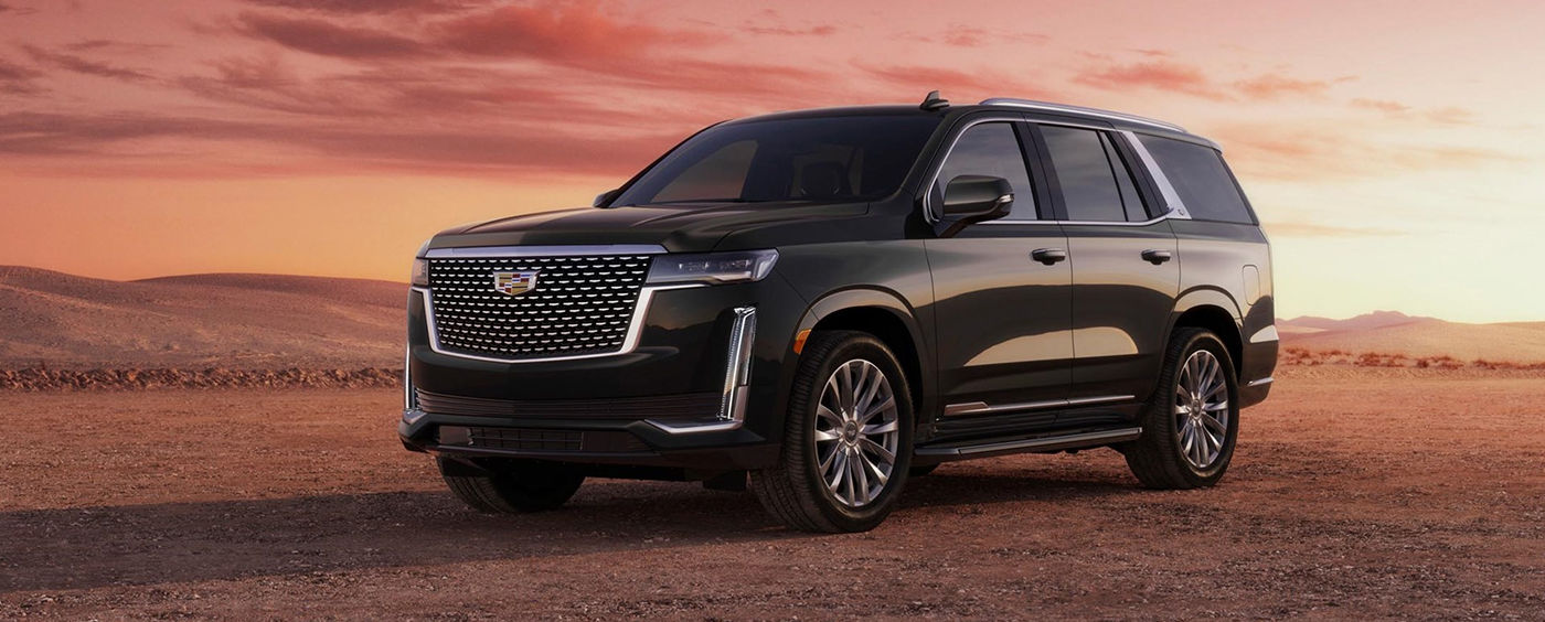 Le VUS Cadillac Escalade 2024 dans le sable avec lever de soleil